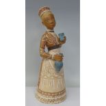 A Margit Kovacs art pottery standing figure, a woman holding a cup and a flask  16.5"h