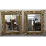 A pair of 19thC mirrors, the later plates set in shell carved and scrolled giltwood frames  23" x