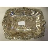 An Edwardian silver dressing table tray with a dished centre, embossed and chased foliate scrolled