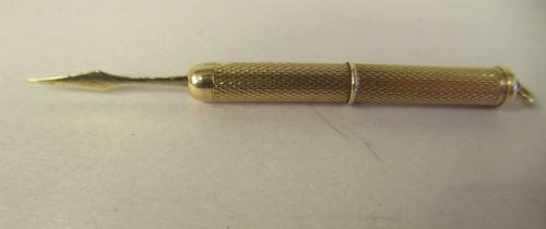 A 9ct gold retractable toothpick, in an engine turned barrel, on a suspension ring