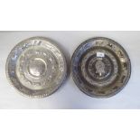 A pair of Indian silver coloured metal plates, each embossed and chased with a central armorial