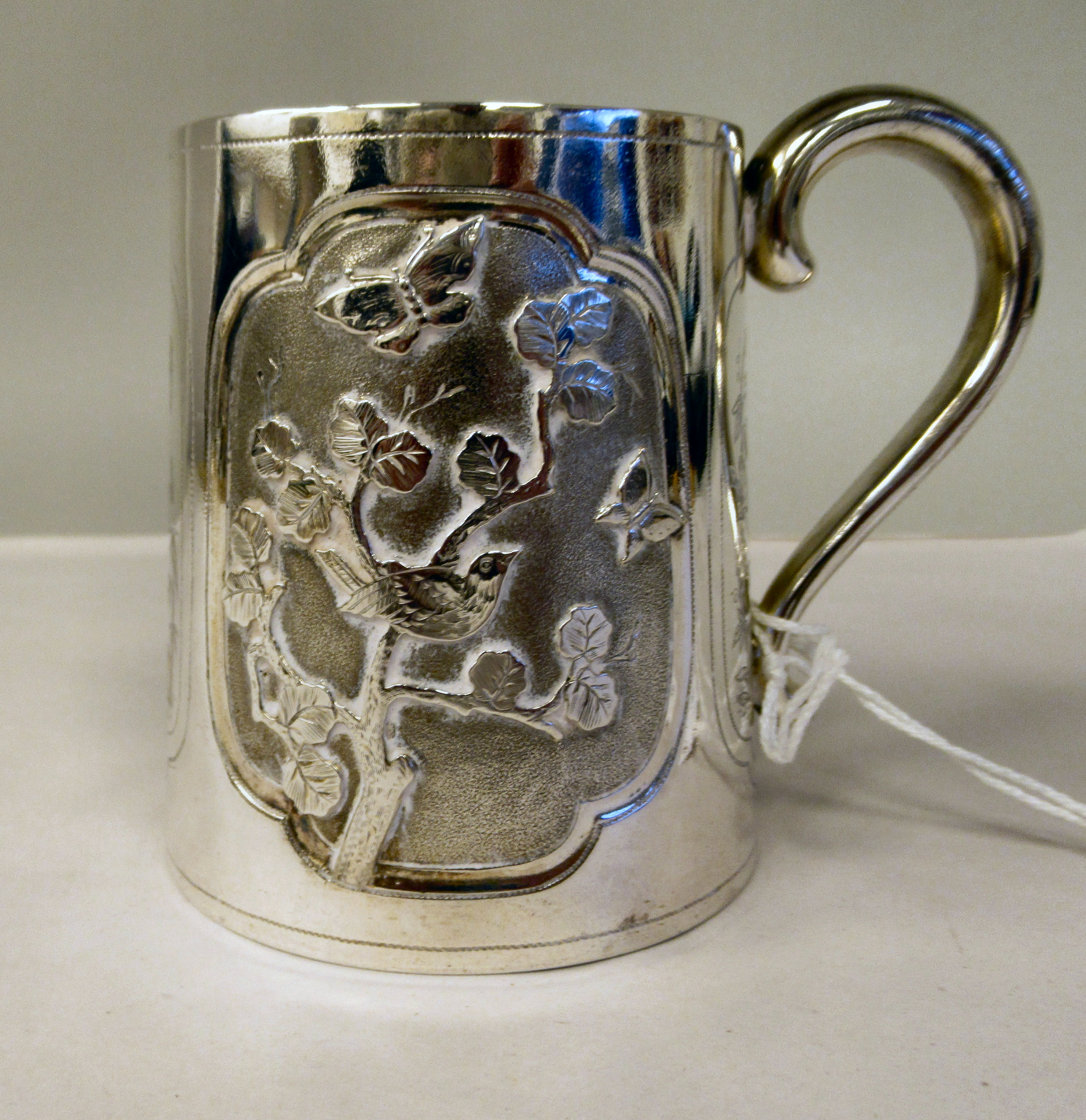 A late Victorian silver half pint Christening mug of tapered form, having a hollow loop handle, cast