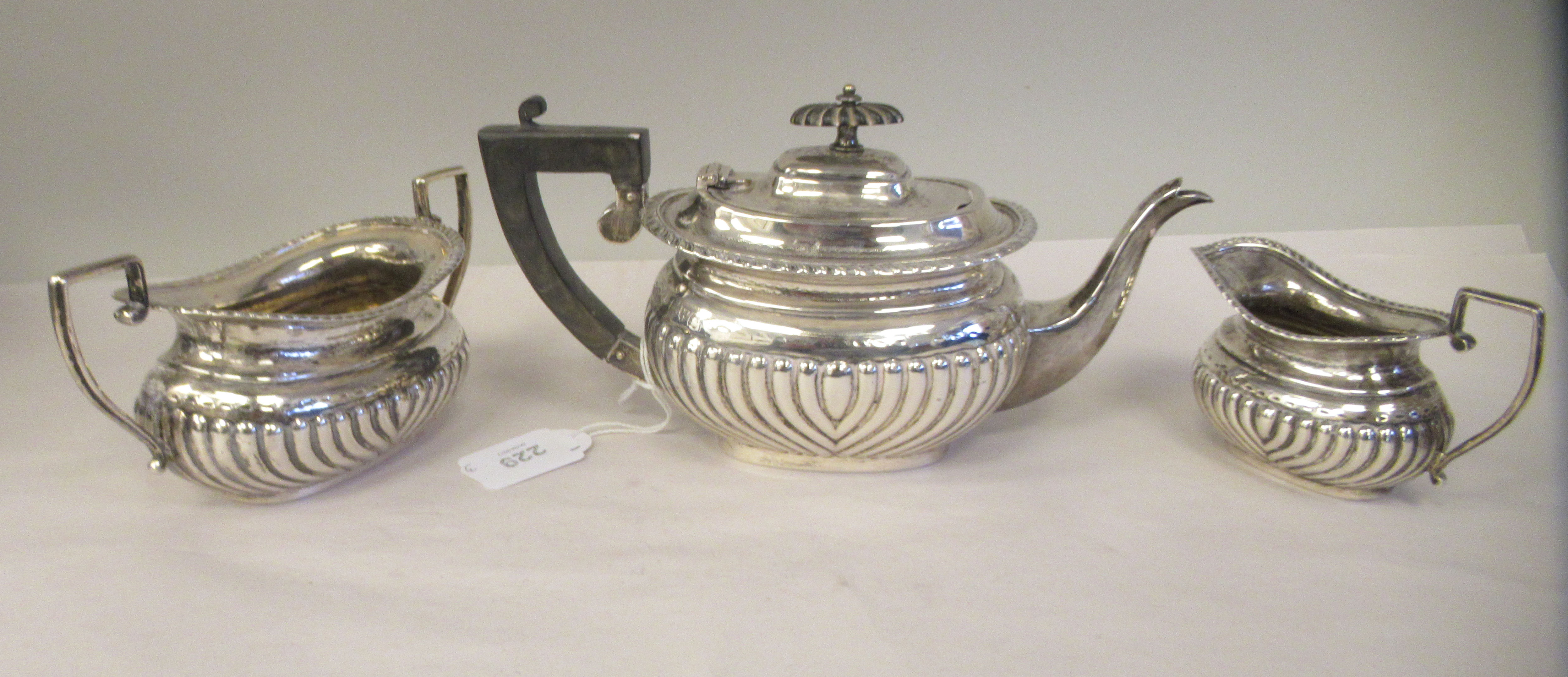 An Edwardian batchelor's three piece silver tea set of oval, ogee shape, demi-reeded form, - Image 2 of 9