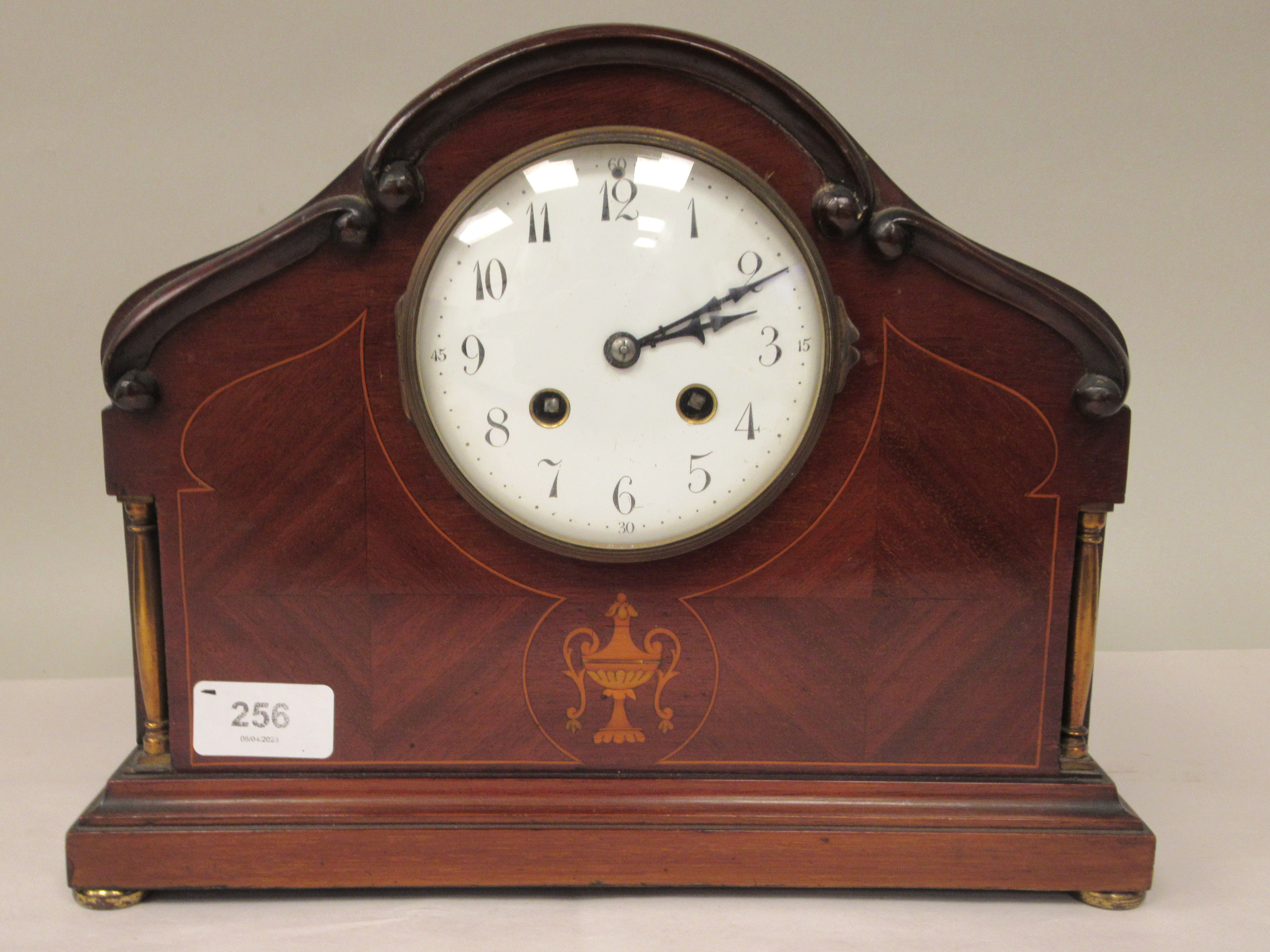 An Edwardian carved, string inlaid mahogany and marquetry cased mantel clock with a round arch top