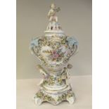 An early 20thC Continental floral encrusted and painted pedestal vase and cover, decorated with
