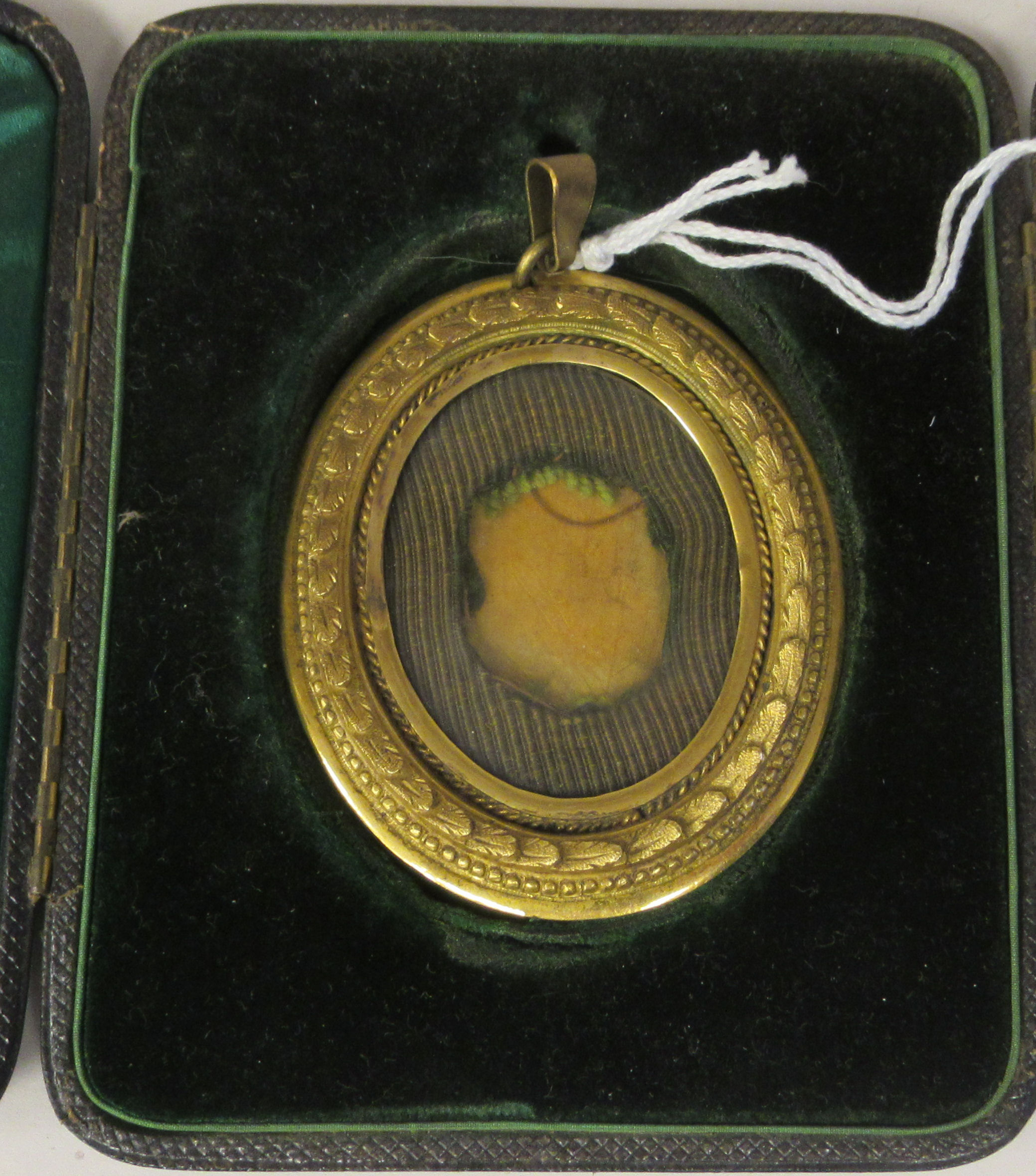 A 19thC gilt metal, glazed oval portrait miniature frame with laurel wreath and bead bordered