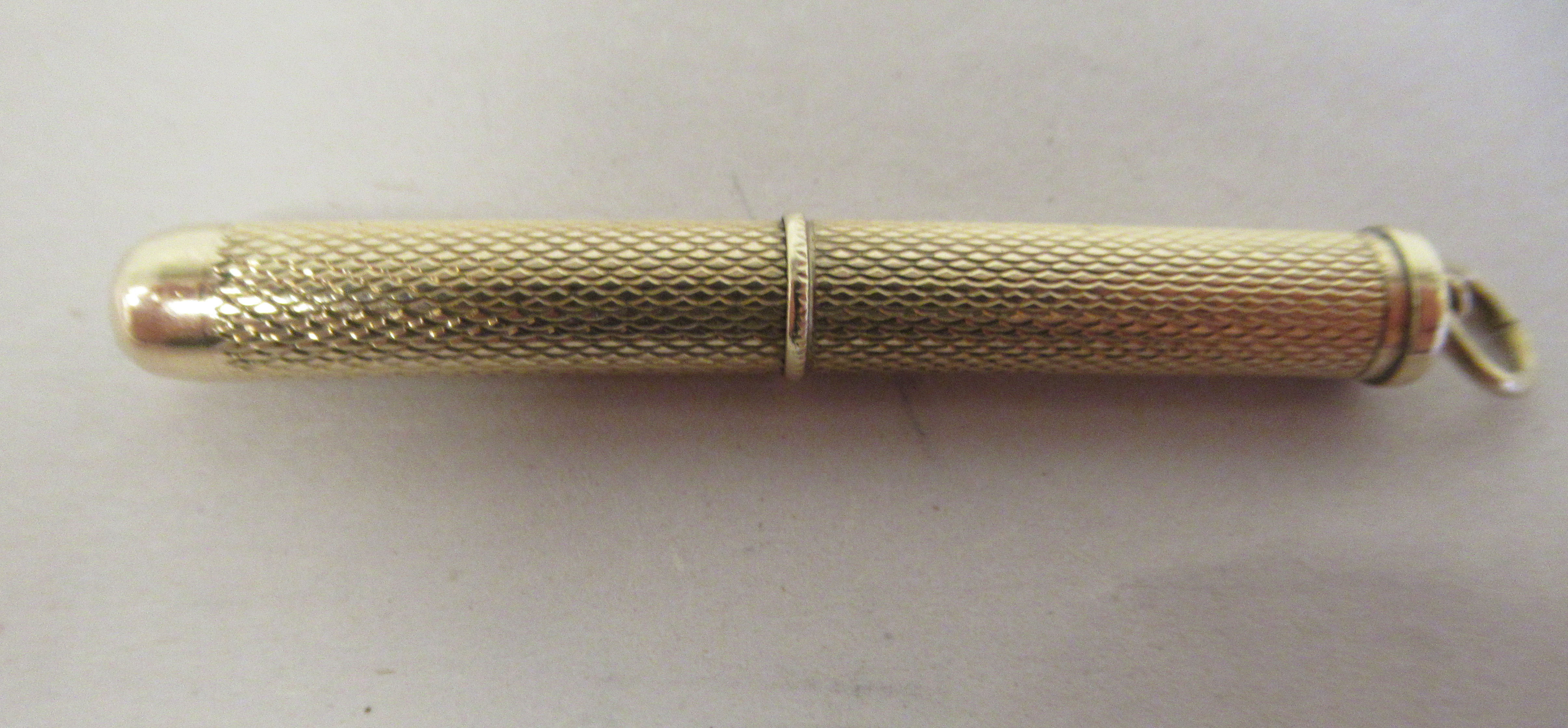 A 9ct gold retractable toothpick, in an engine turned barrel, on a suspension ring - Image 2 of 3