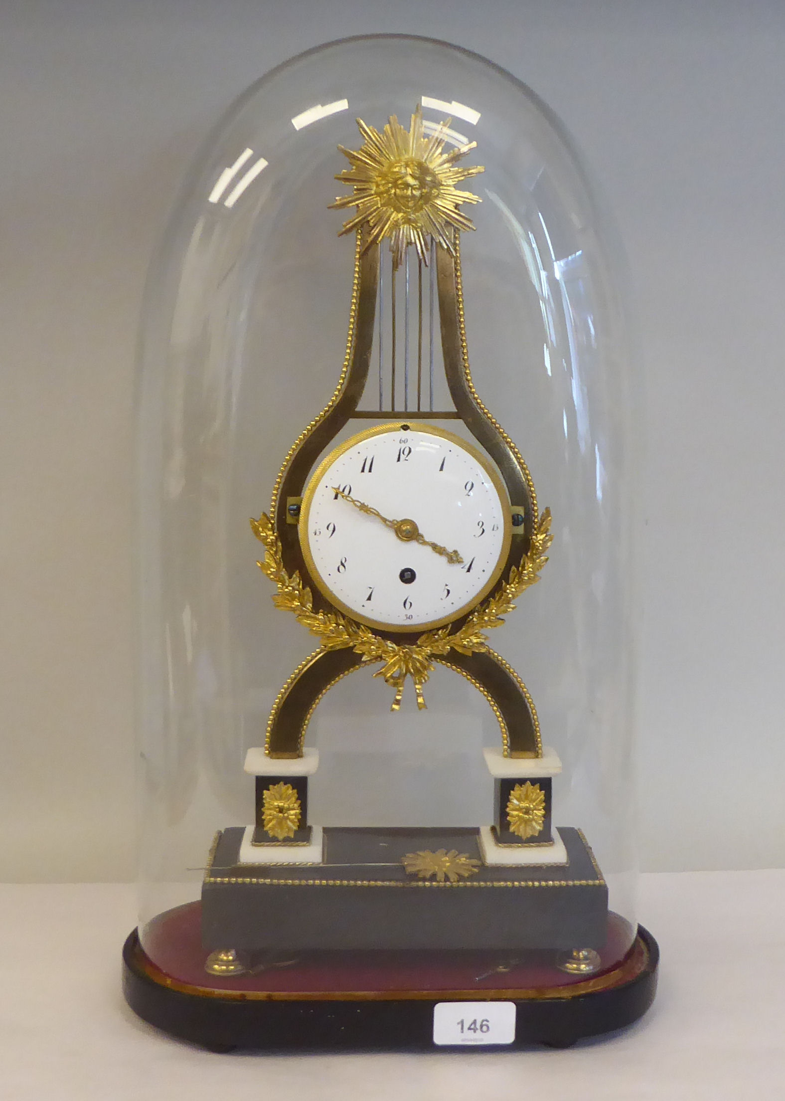 A late 19thC French gilt metal, marble and black slate mantel timepieces of lyre design with a