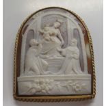 A yellow metal round arch framed, shell carved cameo brooch, depicting the Madonna & Child between