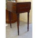 A mid Victorian mahogany Pembroke table with a hinged flap and a fall flap on the obverse, raised on