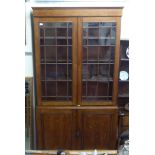 A late Victorian oak cabinet bookcase with two astragal glazed doors, over two panelled cupboard