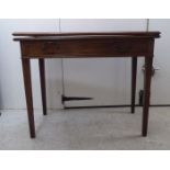 An early 19thC mahogany tea table with a foldover top, over a drawer, raised on square, tapered legs