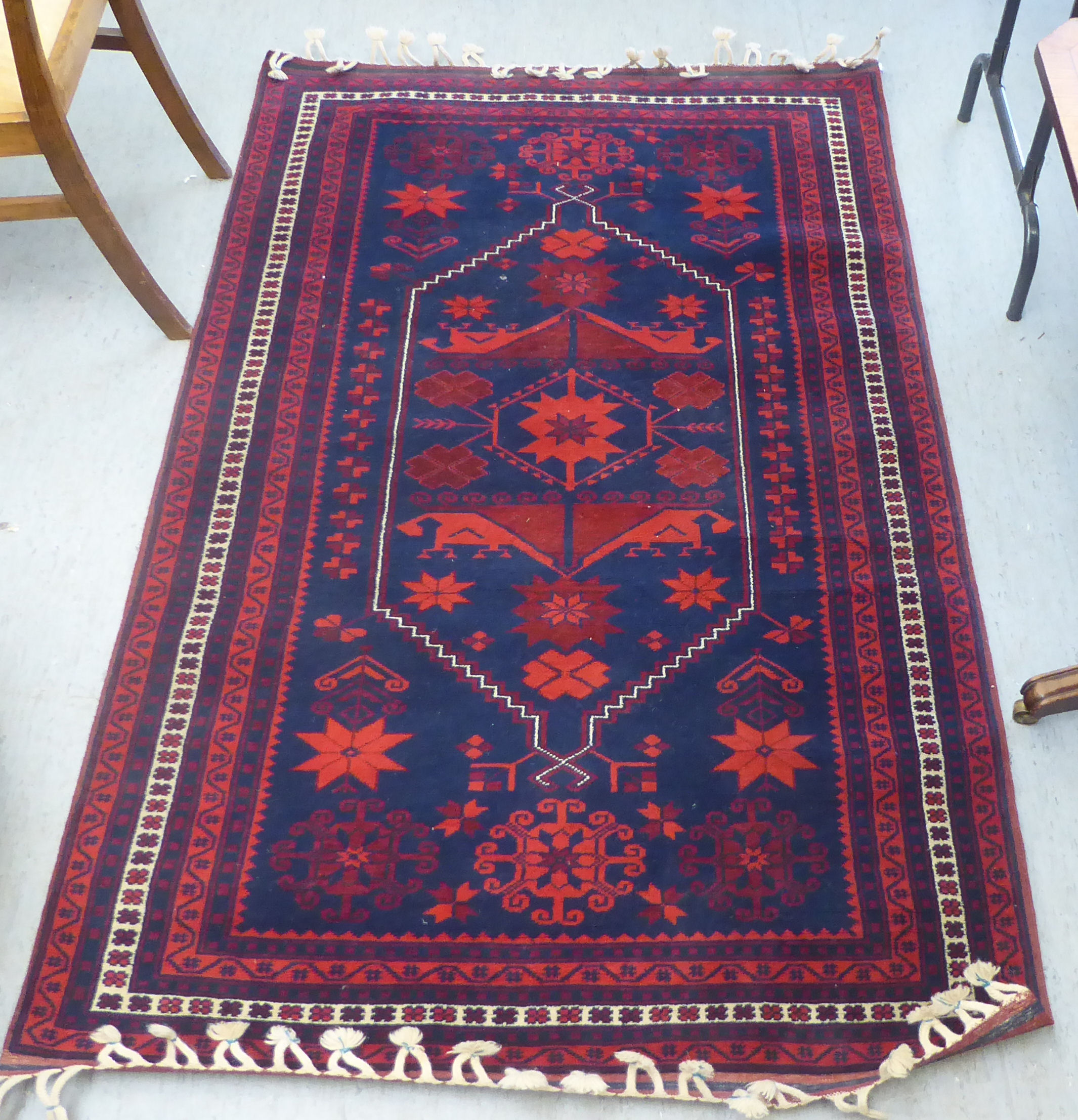 A Turkish rug, decorated with geometric patterns, on a red and blue ground  48" x 78"