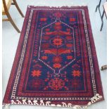 A Turkish rug, decorated with geometric patterns, on a red and blue ground  48" x 78"