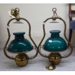 A pair of lacquered brass hanging oil lamps, each with a green glass shade  25"h