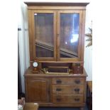 An early/mid 20thC pine cabinet with a glazed bookcase superstructure, over an arrangement of