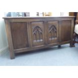 A mid 20thC oak coffer with a hinged lid and tri-panelled front  22"h  43"w