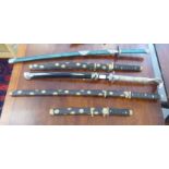 Five modern Japanese Samurai swords, one with a cast metal handle fashioned as a Cobra's head  the