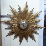 An early 20thC carved and gilded wooden framed sunburst clock; the movement faced by a Roman dial