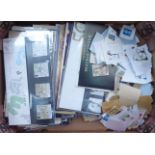 A collection of used postage stamps and unused presentation packs