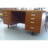 A 1970/80s teak desk with eight drawers, raised on block legs  30"h  66"w
