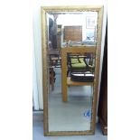 An early/mid 20thC mirror, the bevelled plate set in a moulded gilt frame  21" x 52"