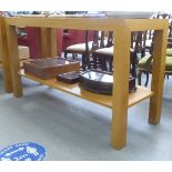 A modern light oak serving table, the top cut with geometric motifs, raised on block legs  36"h