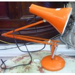 An orange painted metal angelpoise design table lamp