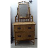 An early 20thC chinoiserie bamboo and rattan dressing table, the bevelled mirror pivoting on upright