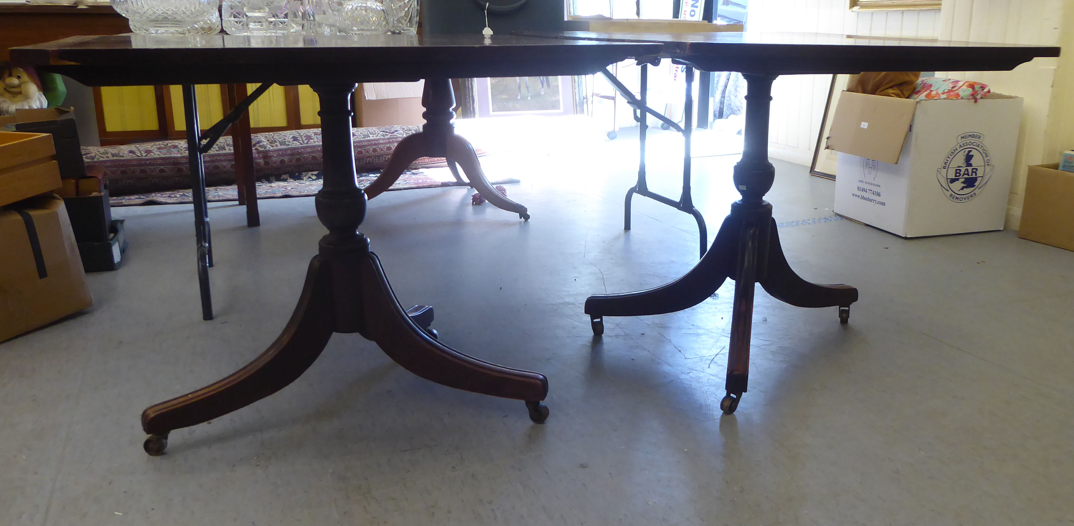 A late George III ebony inlaid, crossbanded mahogany, twin pedestal dining table, raised on splayed,