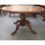 A modern stained pine pedestal dining table  30"h  50"dia