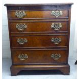 An early 20thC string inlaid walnut bachelors chest with a brushing slide, over four graduated