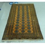 A Turkoman rug, on a burnt orange ground  54" x 108"