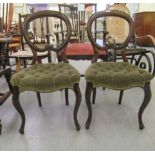 A pair of late Victorian mahogany framed, carved and moulded, balloon back dining chairs, the