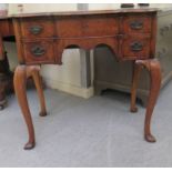 A 20thC lady's Queen Anne inspired walnut veneered, serpentine front kneehole desk, comprising one