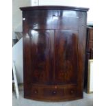 A George III mahogany quadrant hanging corner cabinet with two doors, over a central drawer  48"h