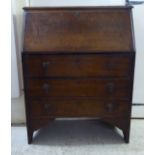 A 1950s oak bureau with a fall flap, over three graduated drawers, raised on bracket feet  38"h