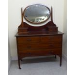 An Edwardian mahogany dressing table, surmounted by an oval mirror, over an arrangement of six