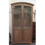 A modern French inspired washed oak bookcase with a pair of full-height glazed and panelled doors,