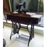 A vintage Singer treadle operated sewing machine no.F5332821, in a dedicated oak and cast iron table