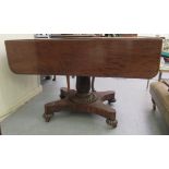 A William IV mahogany Pembroke table with an end drawer, over a turned and carved pedestal, an