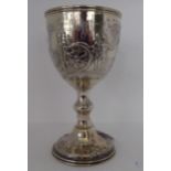 A mid Victorian silver trophy cup of ovoid form, on a knopped pedestal and domed foot, embossed