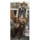 A male life-size mannequin, dressed as a cowboy  78"h
