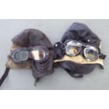 Two brown hide flying helmets; and a pair of googles