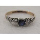 An 18ct gold ring, set with a sapphire, flanked by diamonds
