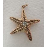 A 9ct gold pendant, fashioned as a starfish, set with a central diamond