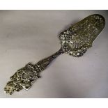 A 19thC German silver coloured metal presentation slice, ornately cast and engraved with figures and