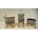 An Edwardian silver three piece octagonal condiments set with pierced sides and blue glass liners
