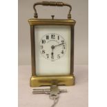 An early 20thC lacquered brass cased carriage clock with bevelled glass panels and a folding top