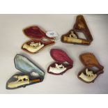 Five 19thC carved meerschaum and amber, cased cheroot holders, variously featuring hunting and other